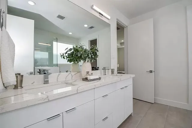 a bathroom with double sink and a mirror