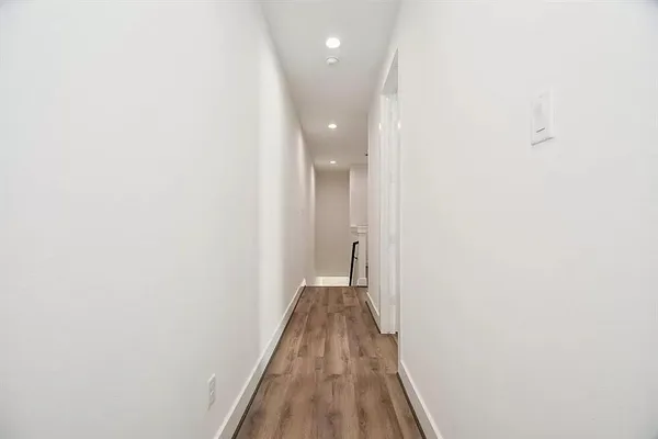 a view of a hallway with wooden floor