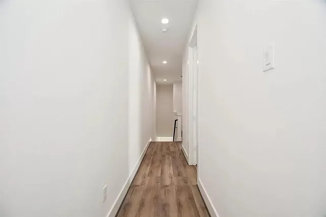 a view of a hallway with wooden floor