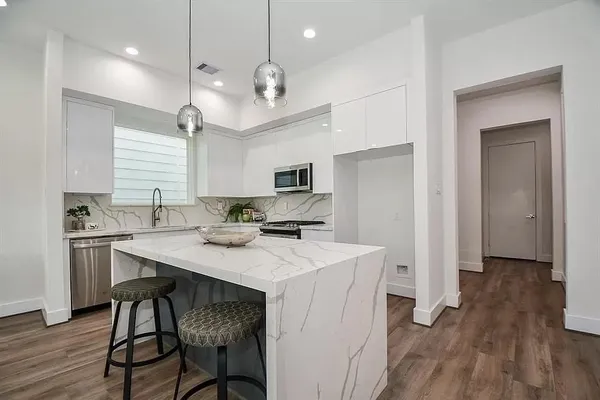 a kitchen with a table chairs refrigerator and microwave