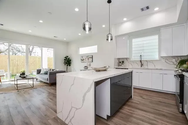 a kitchen with counter top space a sink appliances and living room view