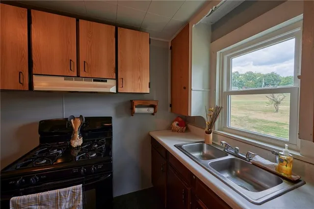 a kitchen with wooden cabinets and a stove top oven