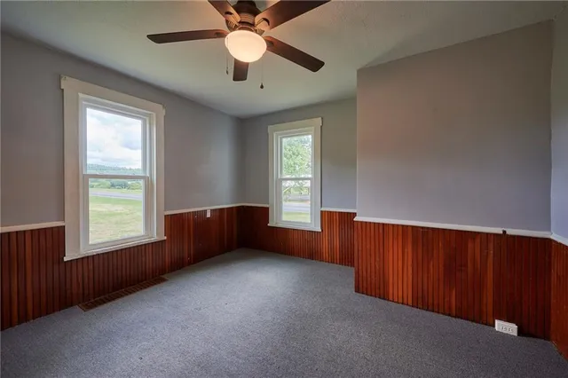 an empty room with windows and fan