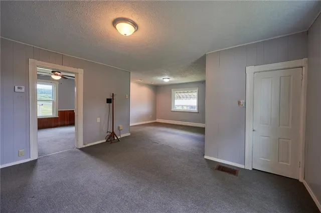 an empty room with windows and bathroom view