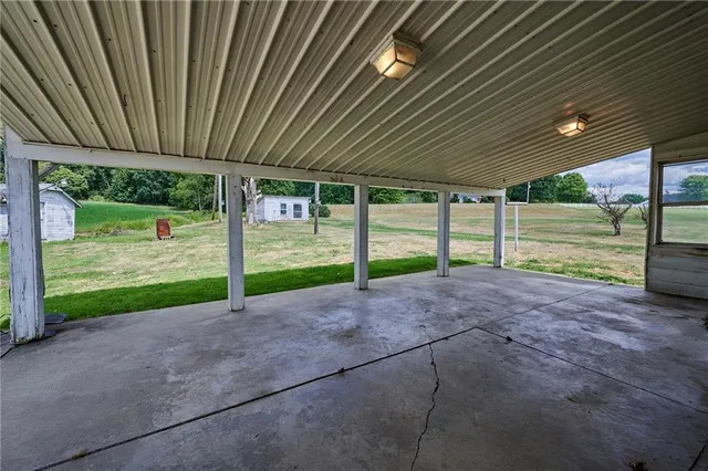 a view of a backyard with floor to ceiling window and tree