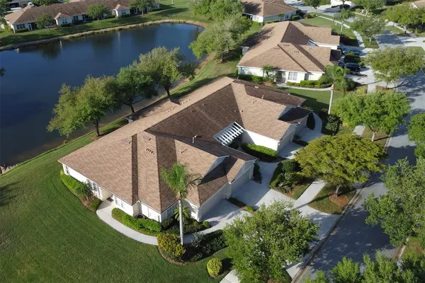 an aerial view of a house with a garden and lake view