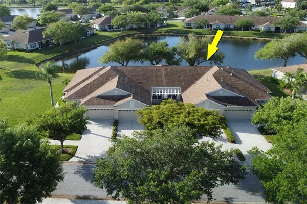 an aerial view of a house with a garden and lake view