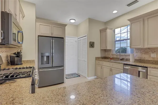 a kitchen with stainless steel appliances granite countertop a refrigerator sink and stove