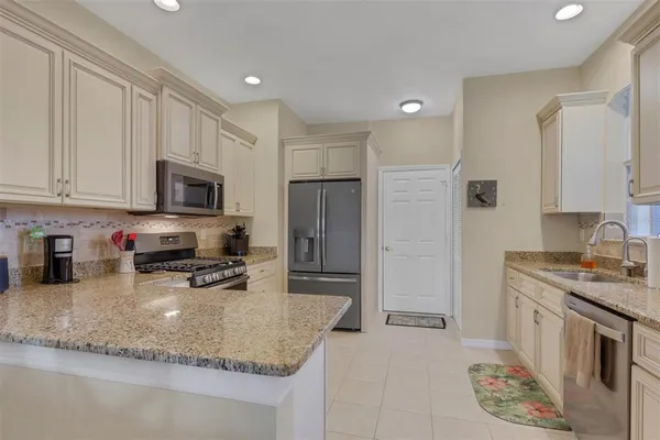 a kitchen with stainless steel appliances granite countertop a sink stove and refrigerator