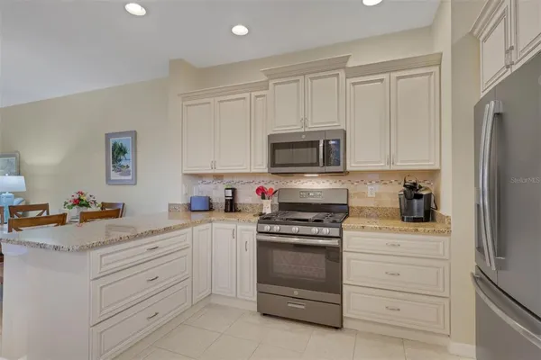 a kitchen with white cabinets and stainless steel appliances