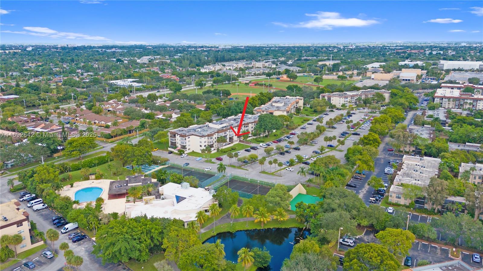 an aerial view of residential houses with outdoor space and trees