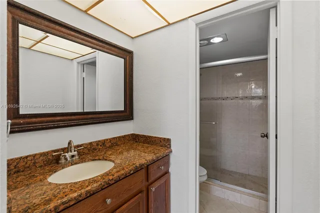 a bathroom with a granite countertop sink mirror and vanity