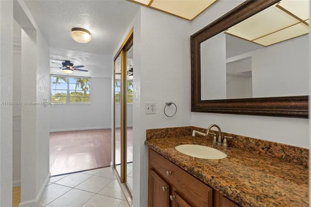 a bathroom with a granite countertop sink and a mirror
