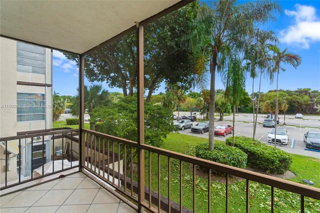 a view of a balcony with potted plants and palm trees