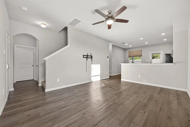 a view of a livingroom with wooden floor and a ceiling fan