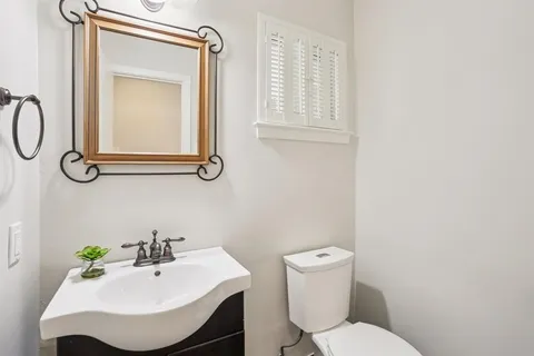 a bathroom with a sink mirror and toilet