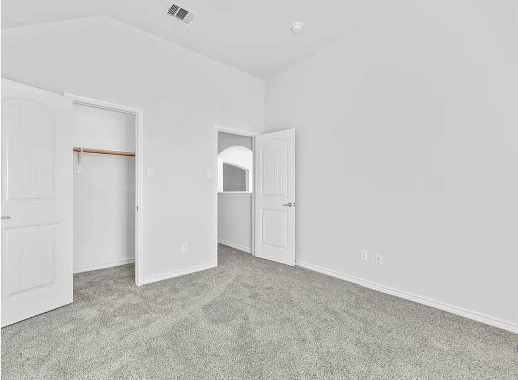8401 Hitching Trail McKinney, TX 75070 - Photo 15 of 39 Unfurnished bedroom featuring carpet, a closet, and vaulted ceiling
