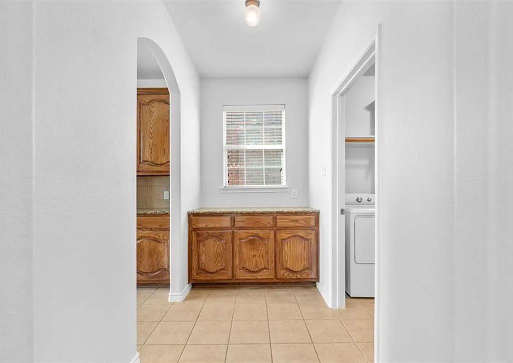 8401 Hitching Trail McKinney, TX 75070 - Photo 21 of 39 Corridor featuring arched walkways, washer / dryer, and light tile patterned floors