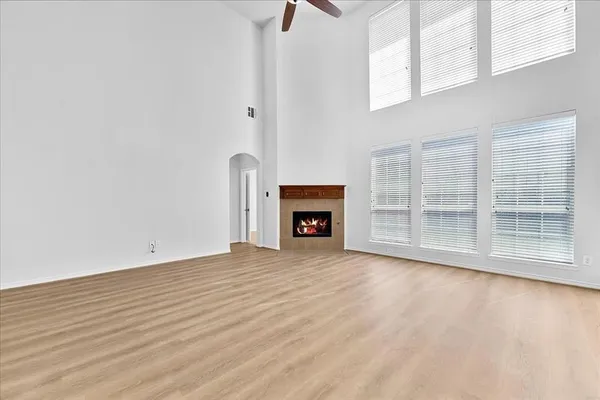 a view of an empty room with a window and fireplace