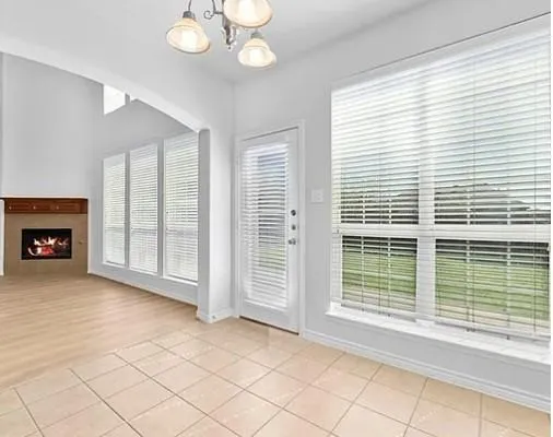 a view of an empty room with a fireplace and a window