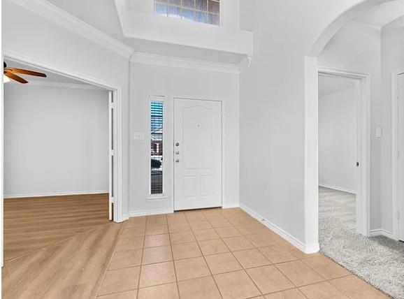 8401 Hitching Trail McKinney, TX 75070 - Photo 29 of 39 Foyer entrance with light tile patterned floors, ceiling fan, a high ceiling, arched walkways, and ornamental molding