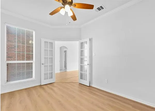 a view of an empty room with a window and a ceiling fan