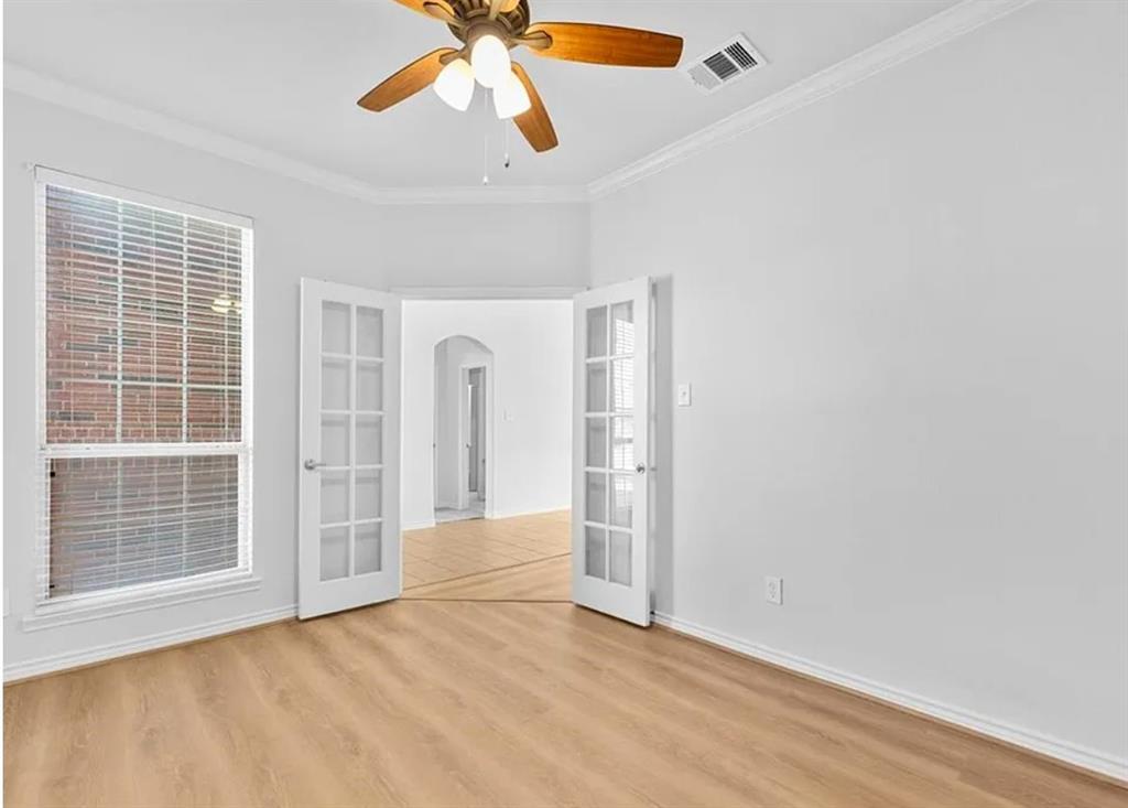 8401 Hitching Trail McKinney, TX 75070 - Photo 35 of 39 Spare room with french doors, arched walkways, crown molding, light wood-style flooring, and ceiling fan