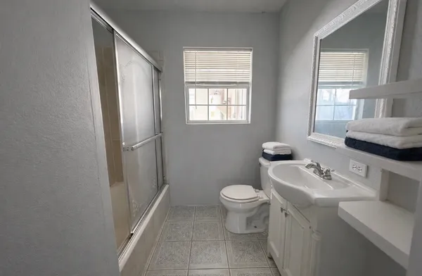 a bathroom with a sink toilet and window