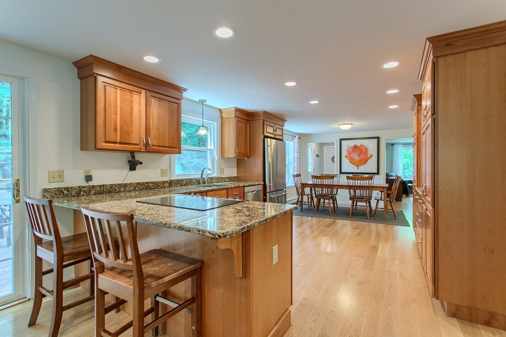 104 Sampson Road Bolton, MA 01740 - Photo 3 of 30 a kitchen with stainless steel appliances granite countertop dining table chairs and a living room view