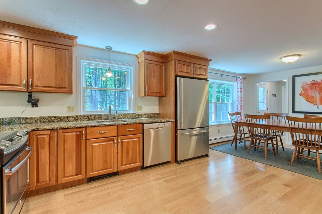 104 Sampson Road Bolton, MA 01740 - Photo 4 of 30 a kitchen with stainless steel appliances granite countertop a refrigerator a sink a stove and island