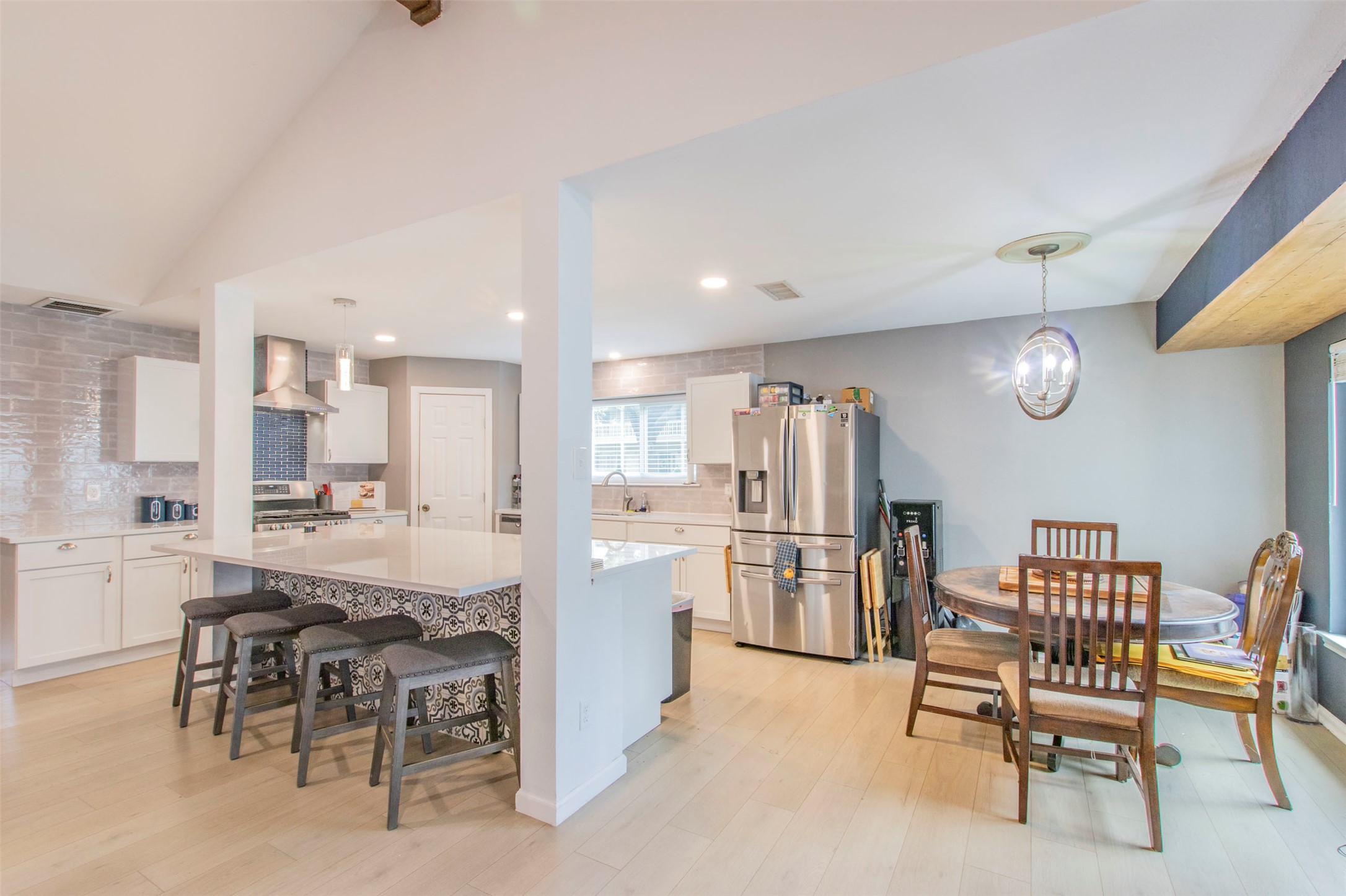 2400 Braemar Cove Austin, TX 78747 - Photo 8 of 20 a kitchen with a dining table chairs refrigerator and cabinets