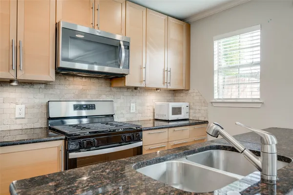 a kitchen with granite countertop a sink and a stove top oven
