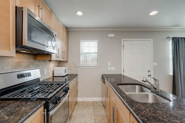 a kitchen that has a sink a stove counter top space and cabinets