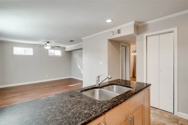 a kitchen with granite countertop a sink a counter top space and cabinets