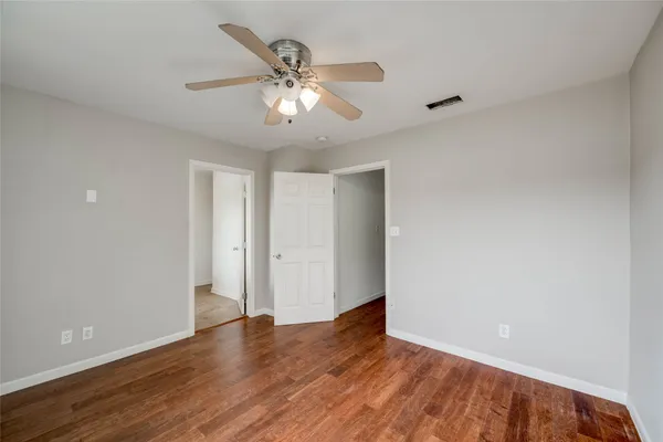 an empty room with wooden floor and window