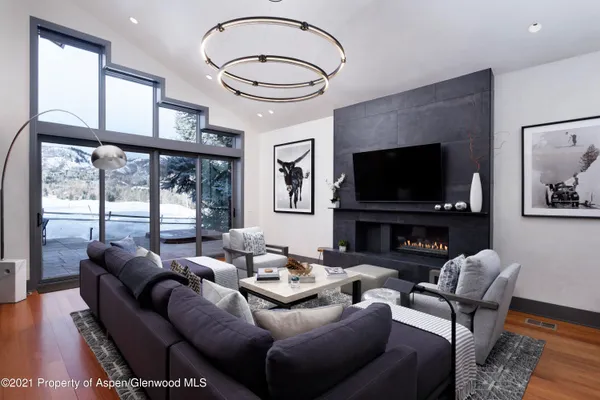 a living room with furniture a large window and a flat screen tv