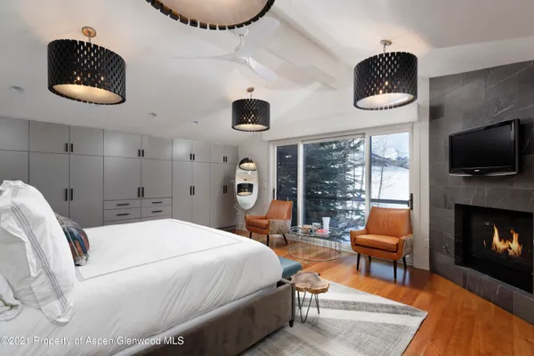a bedroom with a bed a flat screen tv and balcony