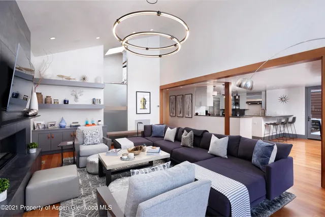 a living room with furniture a rug and a chandelier