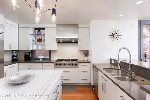 a kitchen with stainless steel appliances kitchen island granite countertop a sink a stove and cabinets