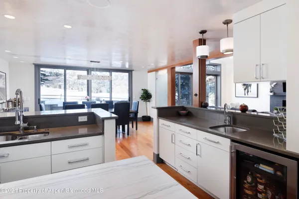 a large kitchen with granite countertop a large window and white cabinets