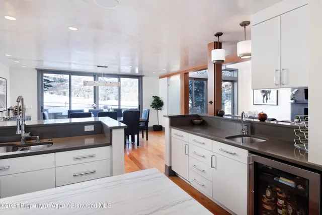 a large kitchen with granite countertop a large window and white cabinets