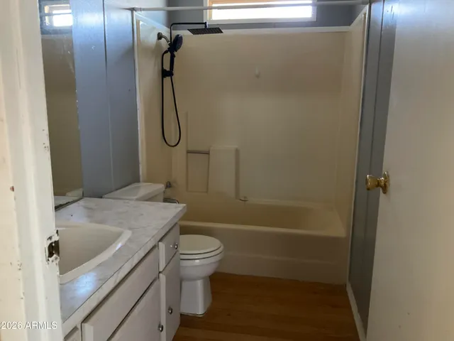 a bathroom with a granite countertop bathtub shower sink vanity and toilet