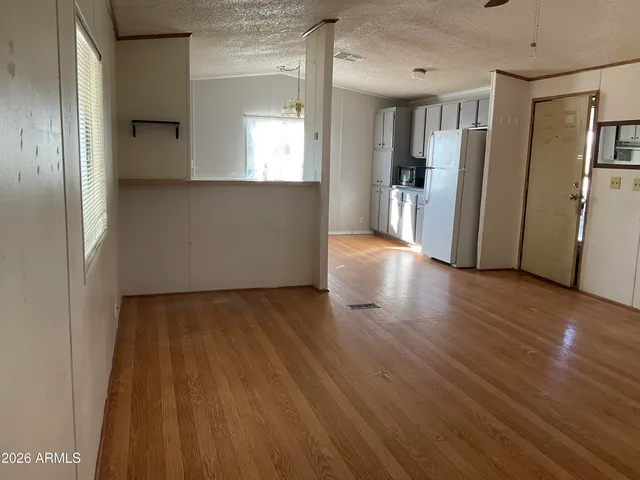 a view of a kitchen with wooden floor and a refrigerator