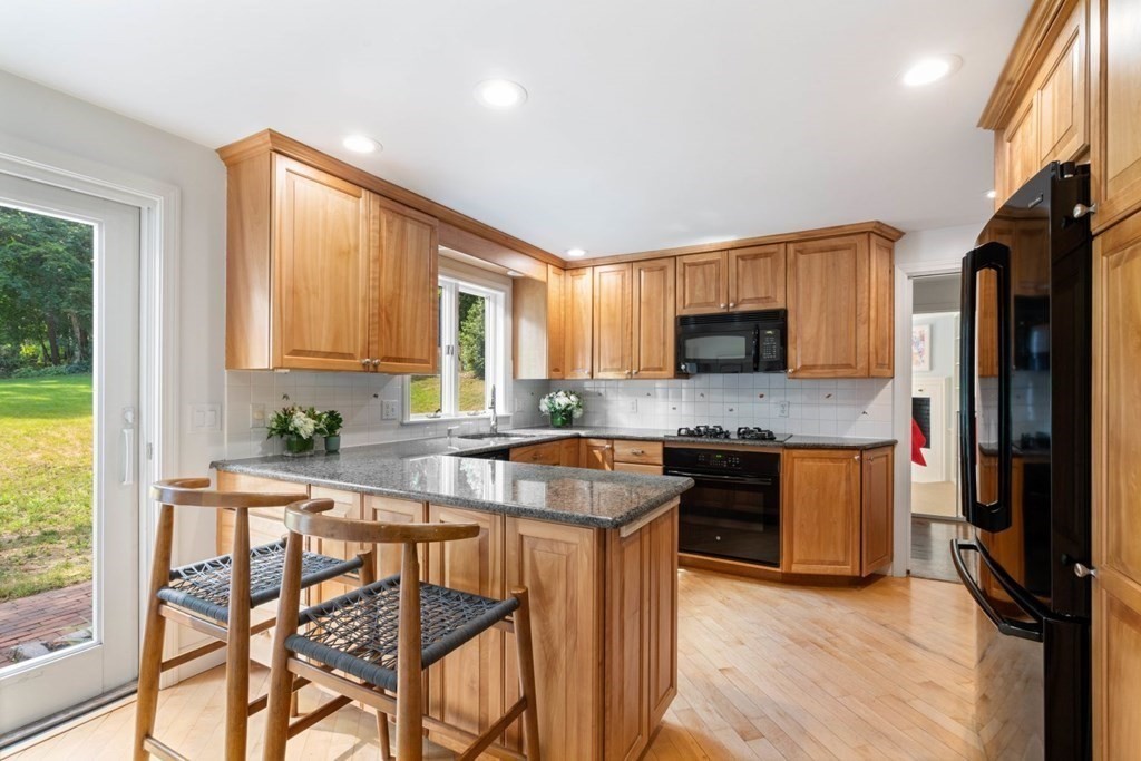 110 Suffolk Road Wellesley, MA 02481 - Photo 17 of 29 a kitchen with stainless steel appliances granite countertop wooden cabinets a stove top oven a sink and dishwasher with wooden floor