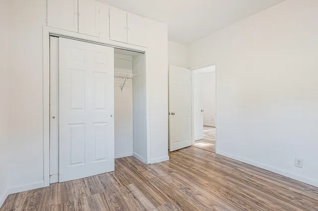 a view of an empty room with wooden floor