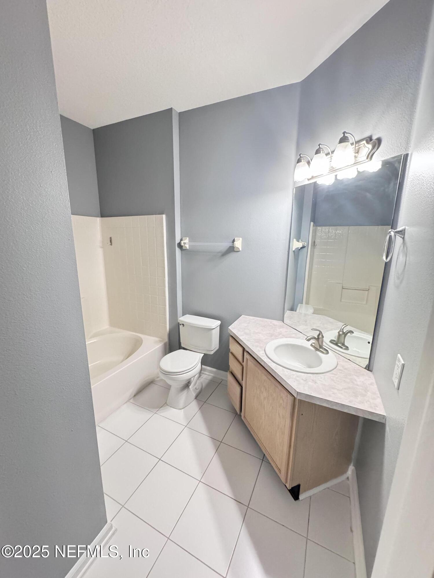 10550 Baymeadows Road, Unit 512 Jacksonville, FL 32256 - Photo 11 of 24 a bathroom with a sink a toilet and a mirror