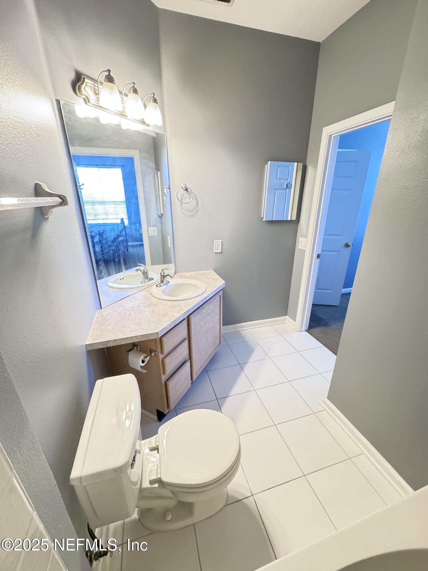 10550 Baymeadows Road, Unit 512 Jacksonville, FL 32256 - Photo 12 of 24 a bathroom with a sink a mirror and a toilet