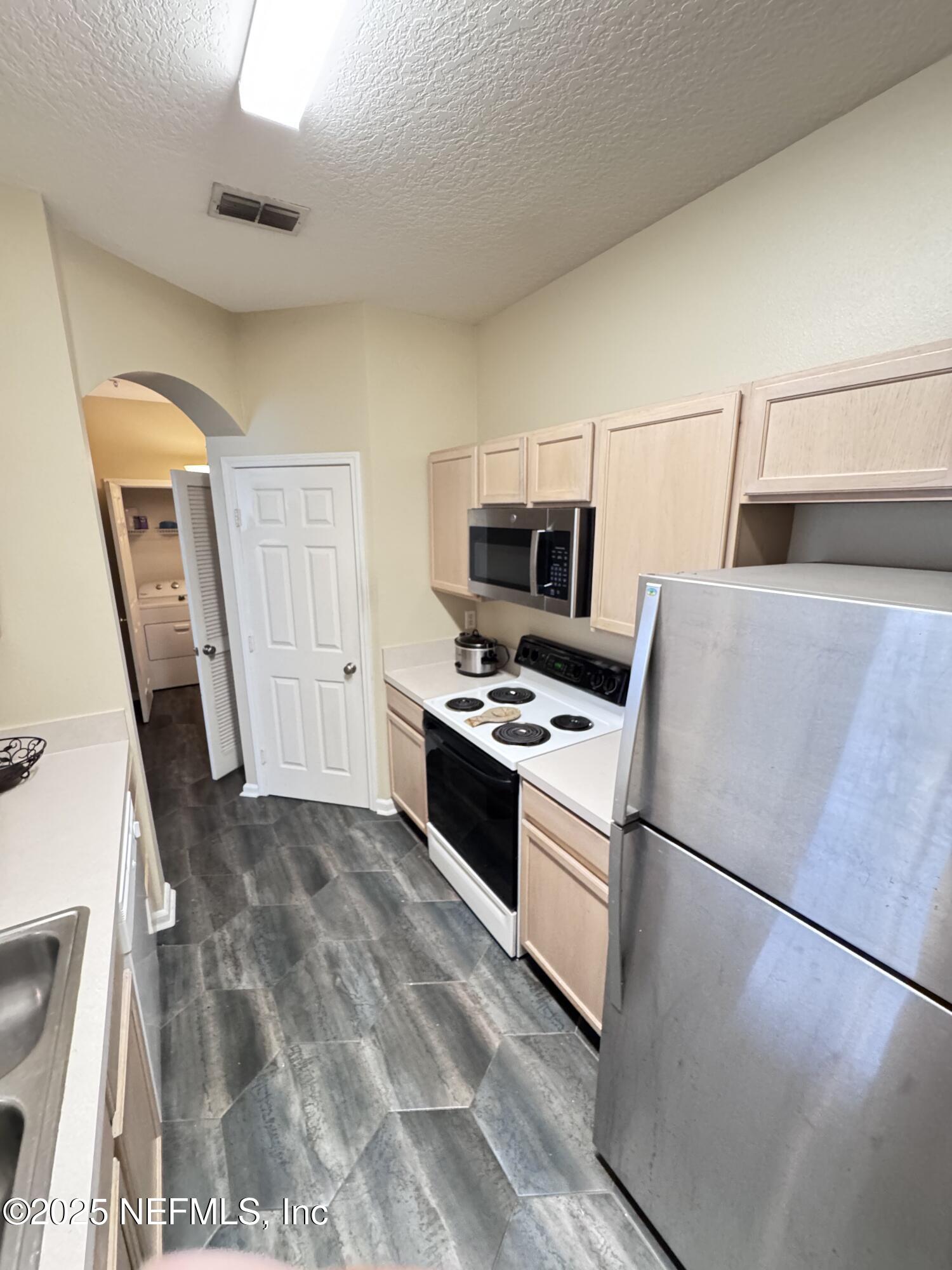 10550 Baymeadows Road, Unit 512 Jacksonville, FL 32256 - Photo 5 of 24 a kitchen with stainless steel appliances a refrigerator stove and sink