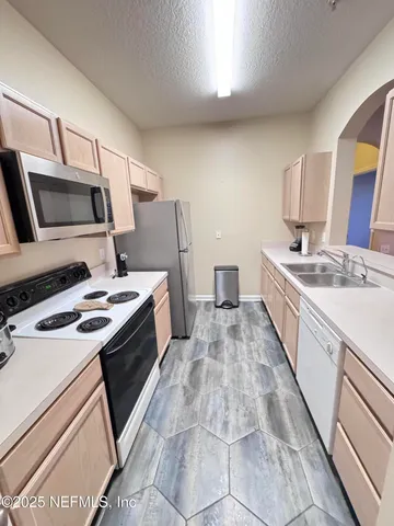 a kitchen with a sink stove and microwave