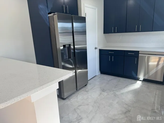 a kitchen with stainless steel appliances a refrigerator and a stove